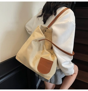 Dettaglio della borsa tote in tela con patch in pelle marrone e spalline di alta qualità