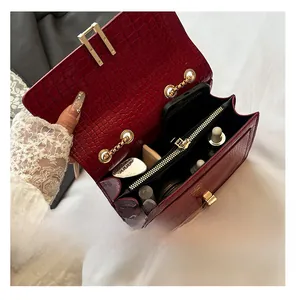 Internal view of burgundy crocodile pattern bag with dual compartments and gold chain