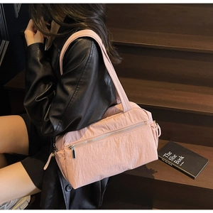 Lifestyle shot of pink nylon tote bag with silver zipper on wooden stairs background