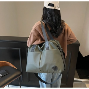 Detail of the army green large travel backpack with reinforced handles and brand logo