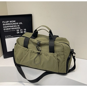 Detailed view of olive green travel bag with elastic drawstring pocket and metal clips
