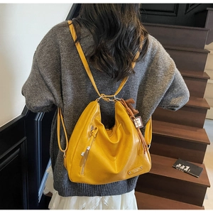 Détail d'un sac convertible en cuir jaune vif porté en sac à dos décontracté dans un escalier