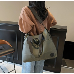 Olive green high-capacity nylon backpack worn by model, showing size and travel utility