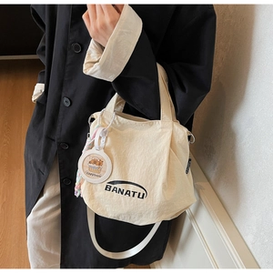 Off-white canvas shoulder bag with BANATU logo and cute Capybara charm accessory