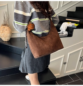 Detail of dark brown suede hobo bag with cute teddy bear charm and large capacity design