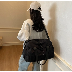 Detail of black waterproof nylon travel bag with multiple pockets and durable shoulder strap