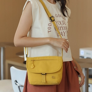 Leuchtend gelbe Nylon-Umhängetasche an einem Model mit einem modischen Outfit