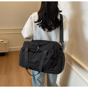 Close-up of black waterproof nylon travel bag with wide straps and drawstring pocket