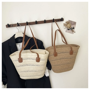 Detail of woven straw tote bags with horizontal stripes and brown PU leather handles
