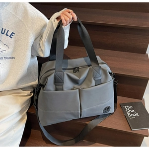 Detail of dark grey large capacity backpack with durable nylon handles and logo patch