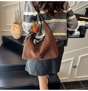 Brown faux suede crescent Hobo bag with plush dog charm and stylish ribbon detail