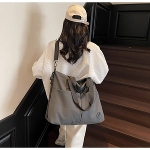 Close-up of a large grey nylon travel backpack with adjustable straps and AIMEIDIA logo