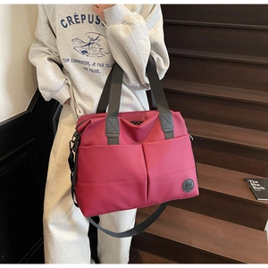 Detail of burgundy nylon travel backpack with front pockets on indoor stairs