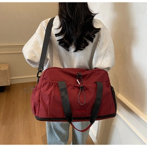 Detail view of burgundy waterproof travel bag with a separate shoe compartment