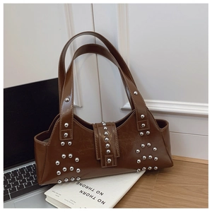 Close-up of vintage dark brown faux leather bag with silver rivets and dual handles