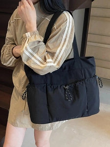 Black nylon tote bag with multi-pocket design shown on model for casual commuting