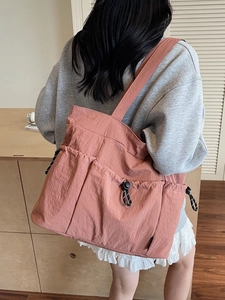 Minimalist dusty pink nylon tote bag with functional pockets and drawstring details