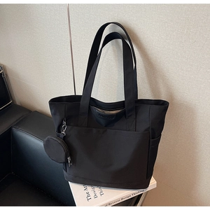 Detail of black tote bag with small coin pouch on minimalist background for daily commuting