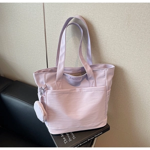 Detail of lilac tote bag with matching coin purse and brand logo on canvas fabric