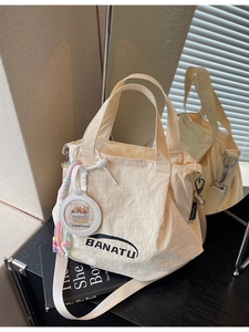 Chic beige ruched tote bag with BANATU logo and cute capybara charm on a shoulder strap