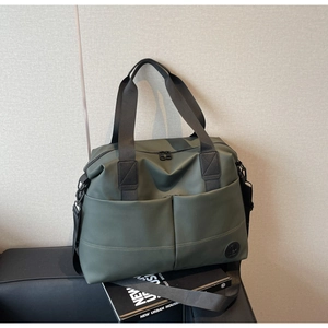 Detail view of large olive green waterproof backpack with sturdy front pockets and black straps
