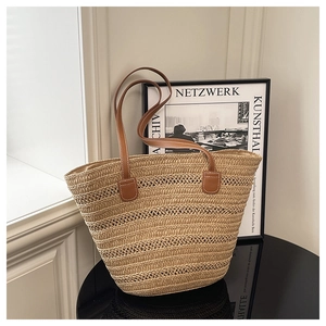 Detailed close-up of straw woven tote bag texture with brown leather strap stitching