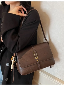 Retro dark brown crossbody bag with matte leather texture and gold metal clasp