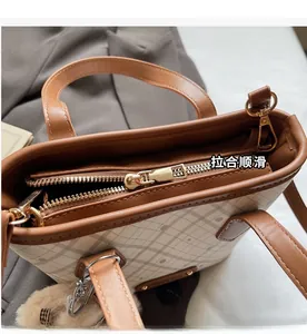Detailed top view of the smooth golden zipper and checkered pattern of the tote bag