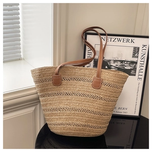 Detail showing beige woven texture and brown leather handles of the large tote bag
