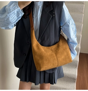 Detail of a vintage brown suede hobo bag with leather strap shown on a staircase