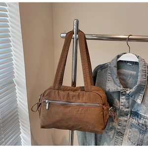 Detailed view of brown nylon tote bag with silver zipper and textured pleated finish