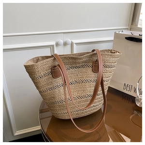 Detailed view of the woven tote bag featuring brown PU leather straps with white stitching