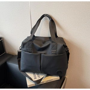Detail of waterproof black travel backpack with multiple pockets and durable nylon handles