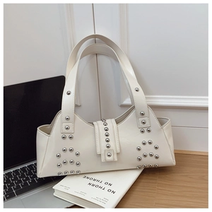 Close-up of white leather shoulder bag featuring silver rivets and metal buckle detail