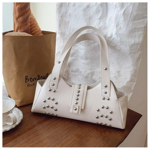 Close-up detail of cream white faux leather shoulder bag with silver rivet decorations