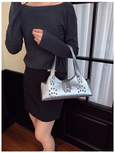 Detail of silver metallic shoulder bag with stud embellishments and Y2K aesthetic