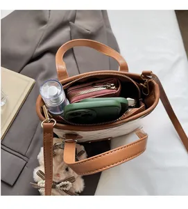 Top view showing the spacious interior of a checkered tote with a pink wallet and phone