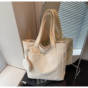 Detail of minimalist cream tote bag with JUMAITU logo and matching round coin purse pouch