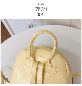 Détail du sac à dos vintage en cuir jaune pâle brillant avec poignée et boucle en métal