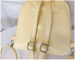 Détail des bretelles réglables avec boucles en métal argenté sur un sac à dos en dentelle crème