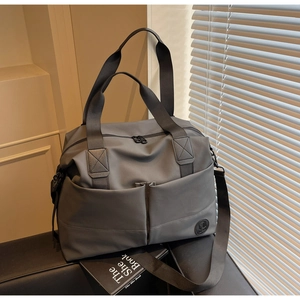 Close-up of grey high-density nylon travel bag with dual pockets and adjustable strap