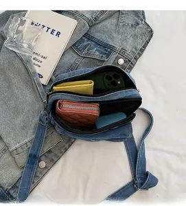 Detail view of denim crossbody bag showing multi-compartment storage and large capacity