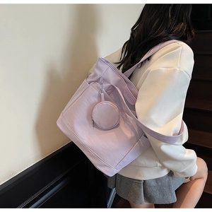Detail of light purple canvas tote bag with side pocket and hanging round coin purse