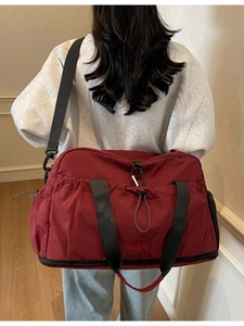 Deep red large capacity travel bag with shoe compartment and adjustable shoulder strap