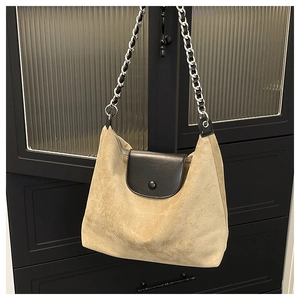 Detail of khaki suede tote with black leather flap and silver chain shoulder strap
