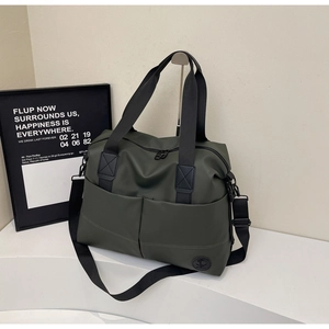 Detail of army green travel tote with reinforced handles and durable nylon fabric texture