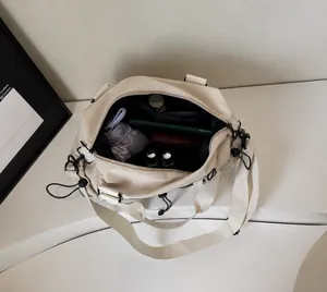 Interior view of cream nylon tote bag with large capacity compartments and drawstring detail