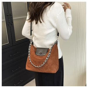 Brown suede tote bag with black leather straps and large silver chain on model