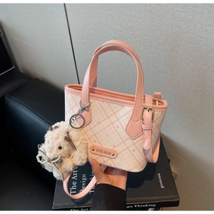 Detail of pink checkerboard tote bag featuring a cute plush bunny and bow decoration