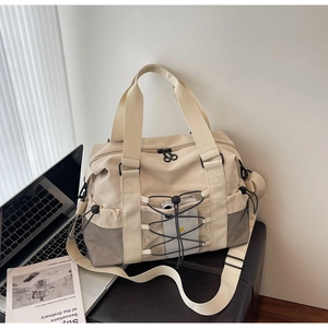 Détail d'un sac de voyage en nylon beige avec cordons élastiques et poche filet